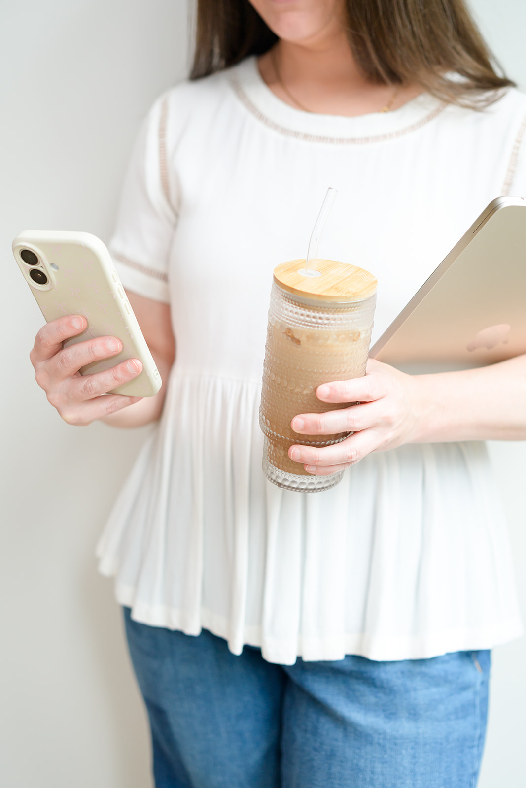 Iced coffee, phone and laptop in hand