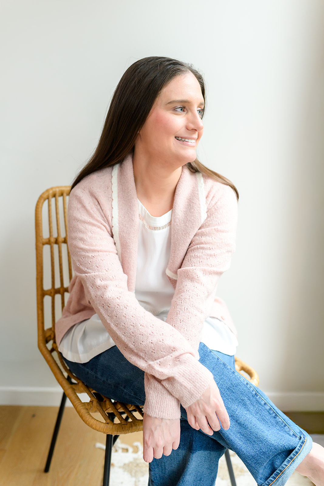 Chelsea in a blush cardigan, seated and smiling